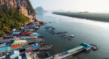 Colorful floating houses and fishing boats along the calm waters in Phuket, Thailand.