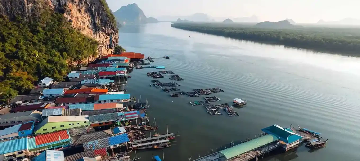 Colorful floating houses and fishing boats along the calm waters in Phuket, Thailand.