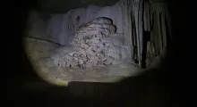 Stalactites and rock formations in a cave in Phuket, illuminated by a flashlight.
