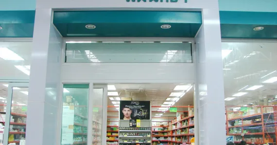 Аптека в Пхукете с яркими полками и рекламным плакатом внутри.