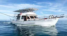 Luxury fishing charter boat cruising in the clear waters of Phuket, Thailand.