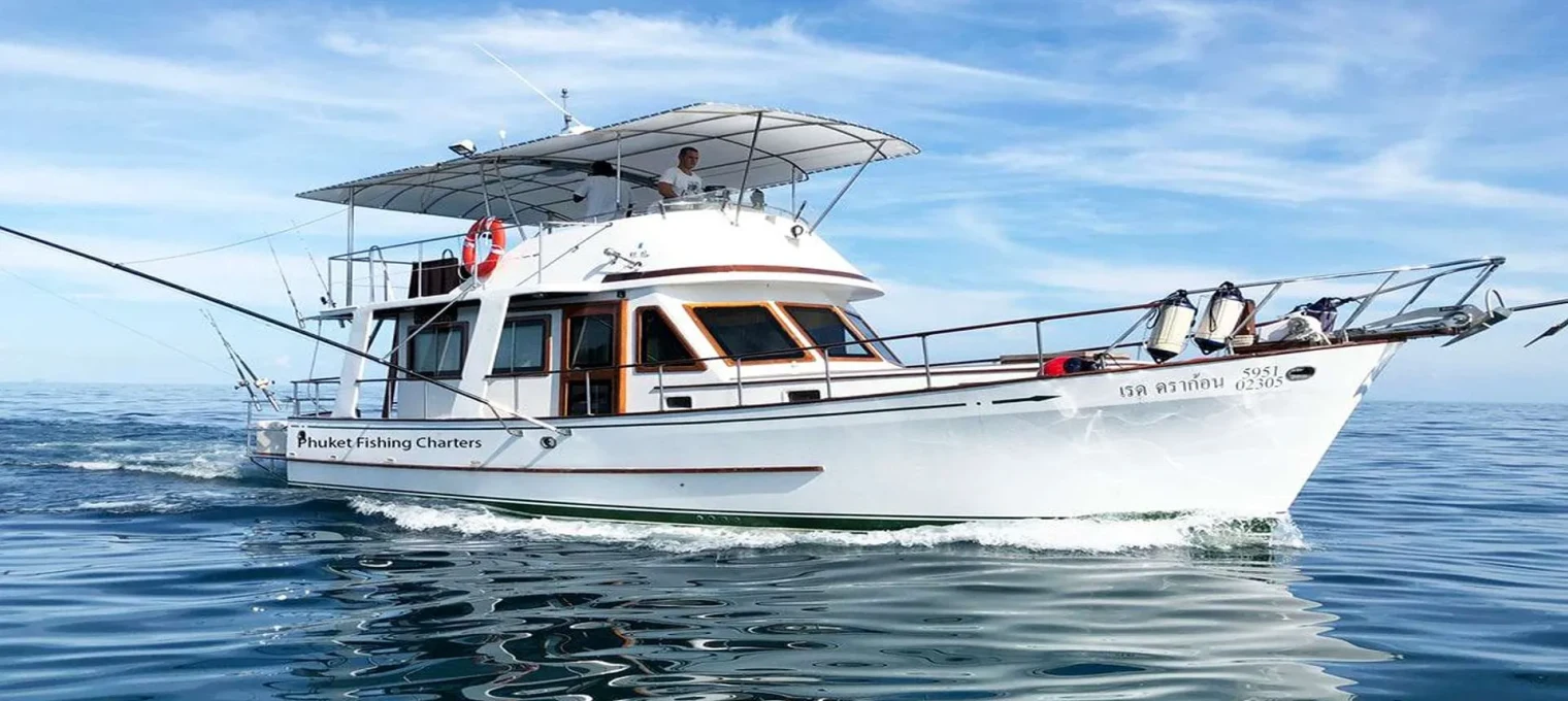 Luxury fishing charter boat cruising in the clear waters of Phuket, Thailand.