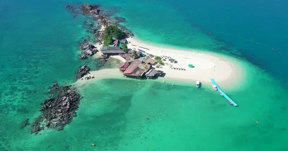 Aerial view of a tropical island in Phuket with clear turquoise waters and sandy beach.