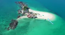 Aerial view of a tropical island in Phuket with clear turquoise waters and sandy beach.