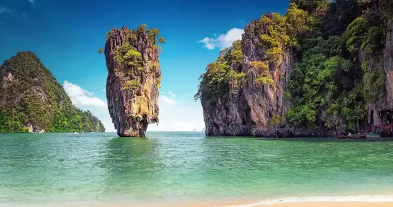 Phuket coastline featuring towering limestone cliffs and clear turquoise waters.
