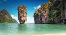 Phuket coastline featuring towering limestone cliffs and clear turquoise waters.