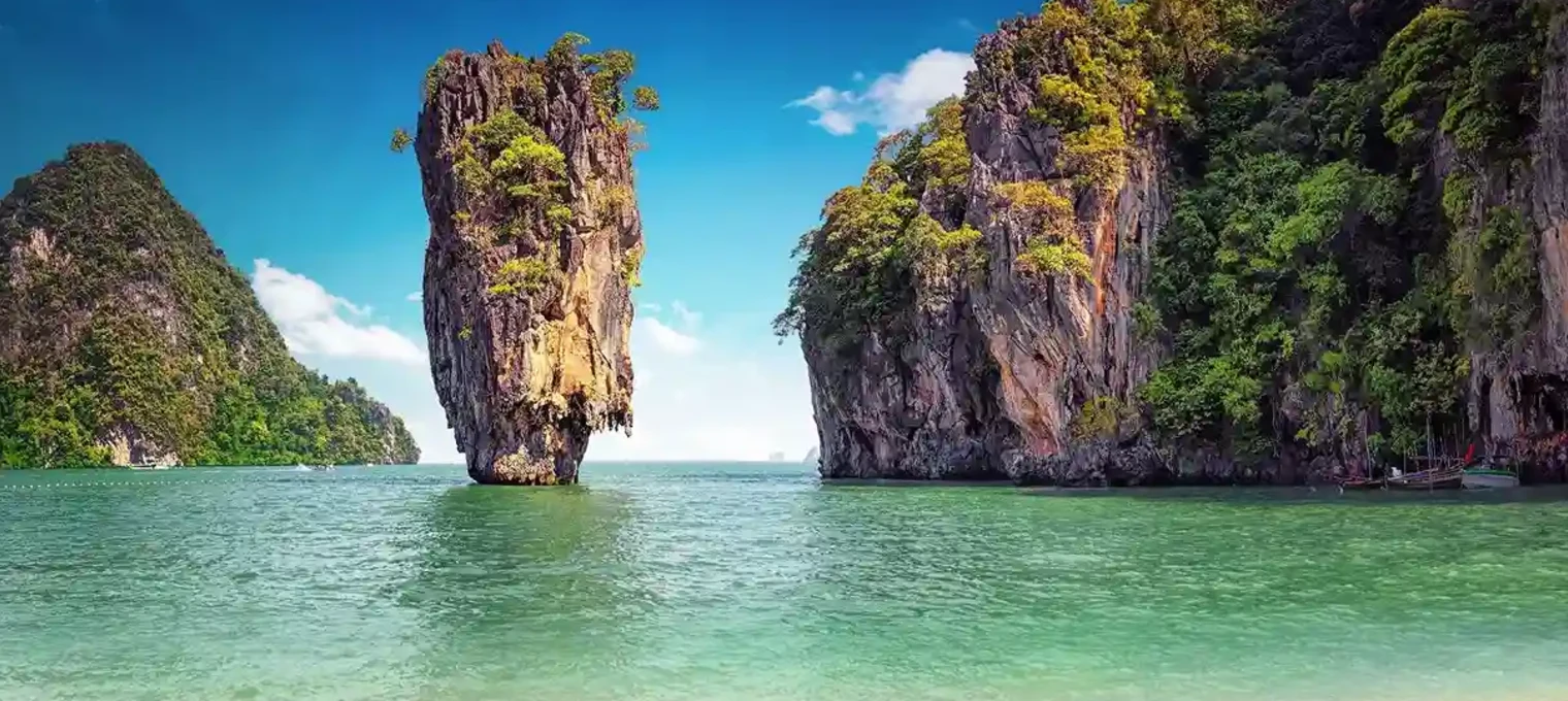 Phuket coastline featuring towering limestone cliffs and clear turquoise waters.