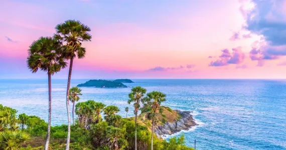 Красивая пляжная сцена на Пхукете с пальмами и морем на фоне заката.