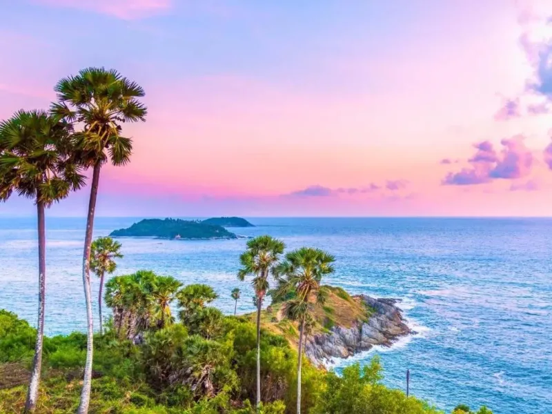 Красивая пляжная сцена на Пхукете с пальмами и морем на фоне заката.