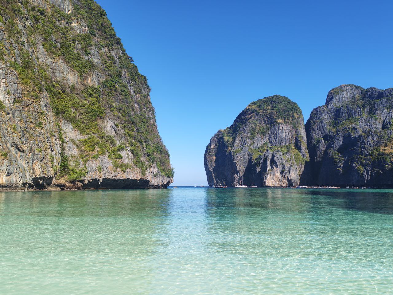Crystal-clear waters and dramatic limestone cliffs at a stunning beach in Phuket.