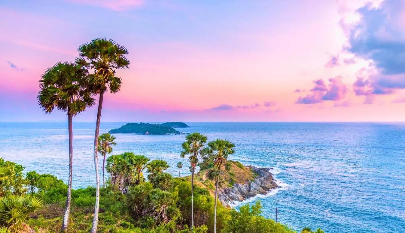 Красивая пляжная сцена на Пхукете с пальмами и морем на фоне заката.