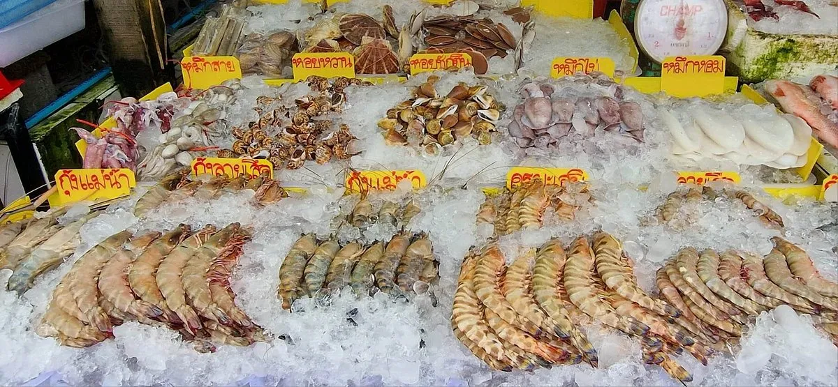 Свежие морепродукты на прилавке рынка в Пхукете, окруженные льдом и ценников.