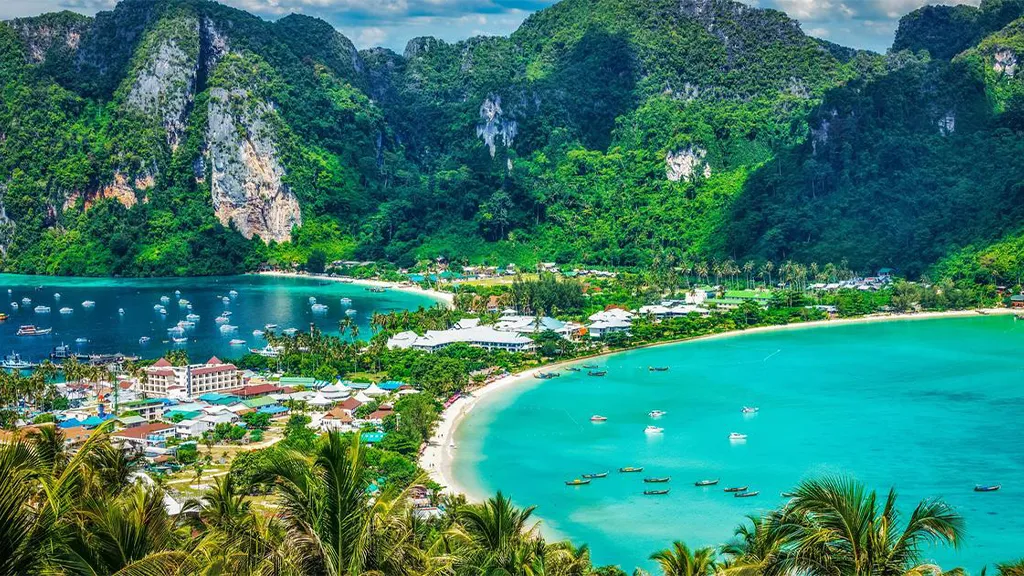 Scenic view of Phuket with lush mountains, turquoise water, and boats in the bay.