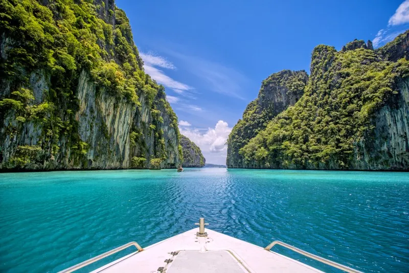 Breathtaking view of turquoise waters surrounded by lush cliffs in Phuket, Thailand.