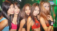 Group of five young women posing together in a vibrant nightlife setting in Phuket.