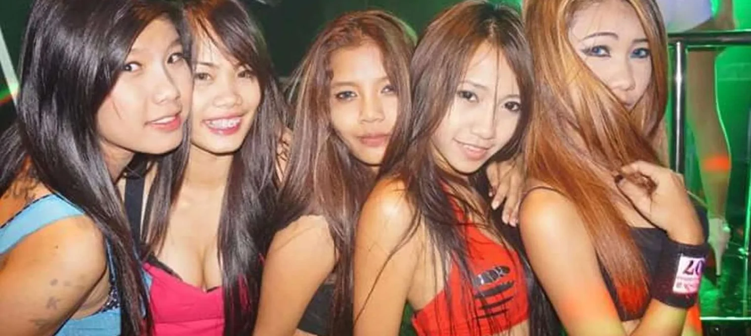 Group of five young women posing together in a vibrant nightlife setting in Phuket.