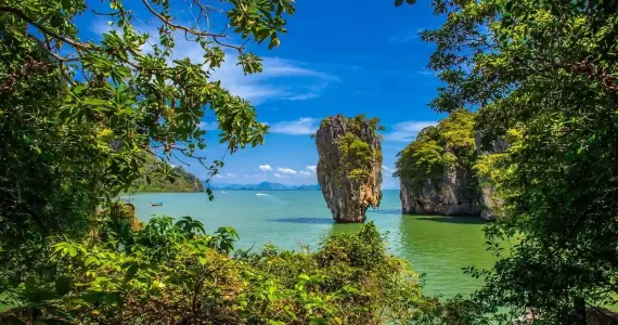Lush greenery frames a stunning view of rocky islands in the turquoise waters of Phuket.