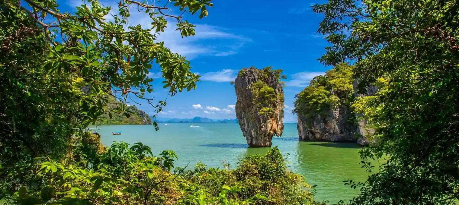 Lush greenery frames a stunning view of rocky islands in the turquoise waters of Phuket.