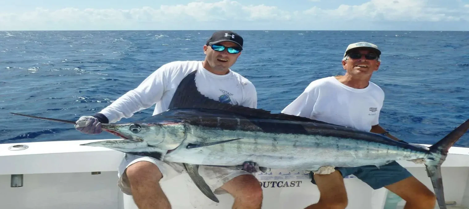 Two men proudly display a large marlin they caught while fishing in Phuket waters.