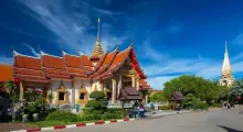 Beautiful temple in Phuket with ornate architecture and lush green surroundings.