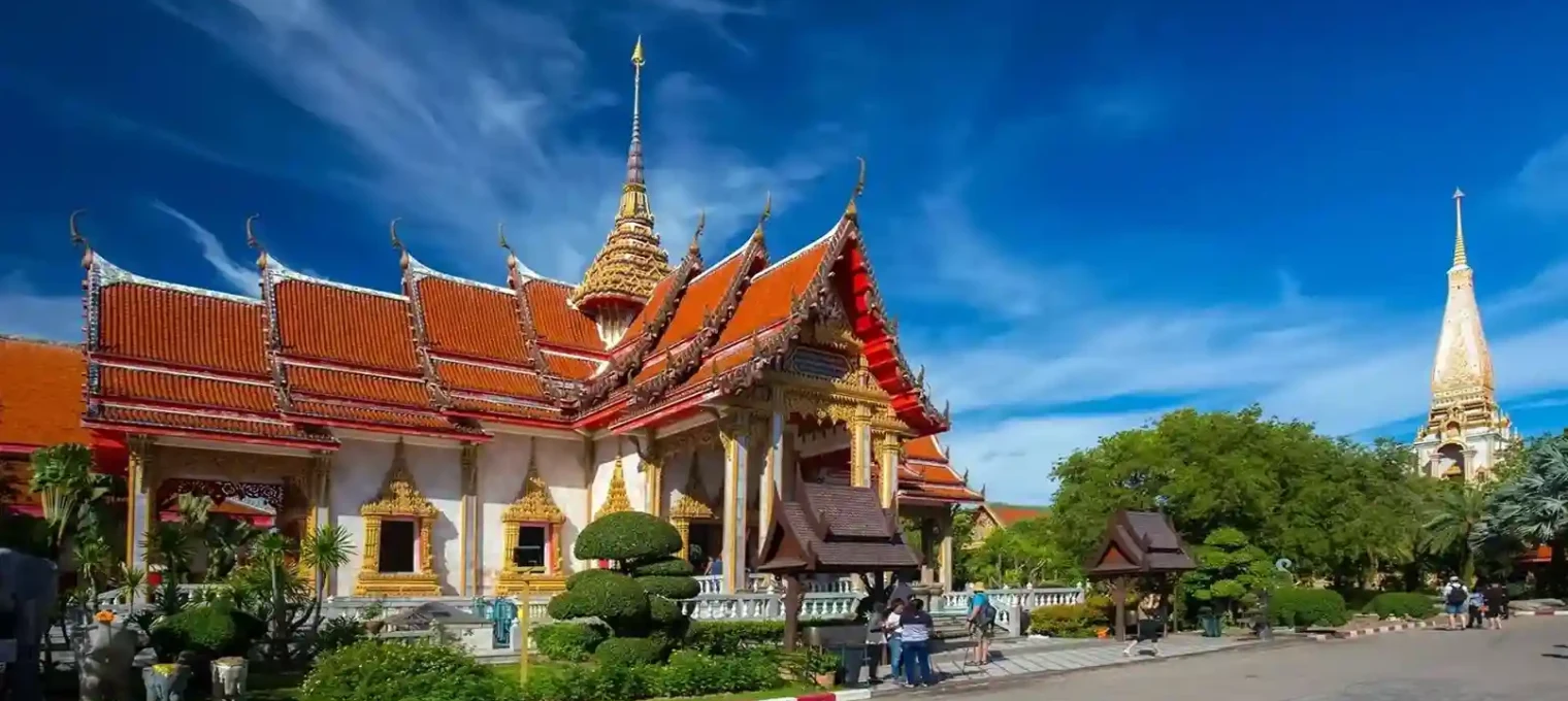 Beautiful temple in Phuket with ornate architecture and lush green surroundings.