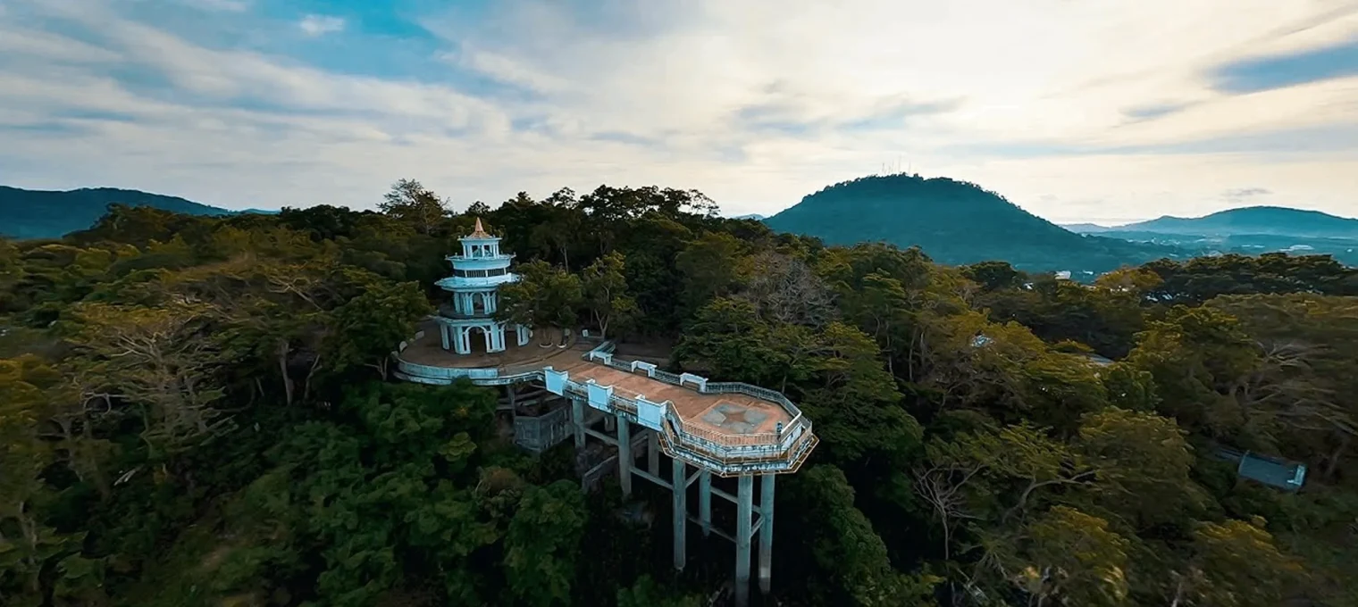 A scenic view of a tower overlooking lush greenery in Phuket, Thailand.