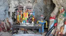 Colorful altars adorned with flowers inside a cave in Phuket, Thailand.