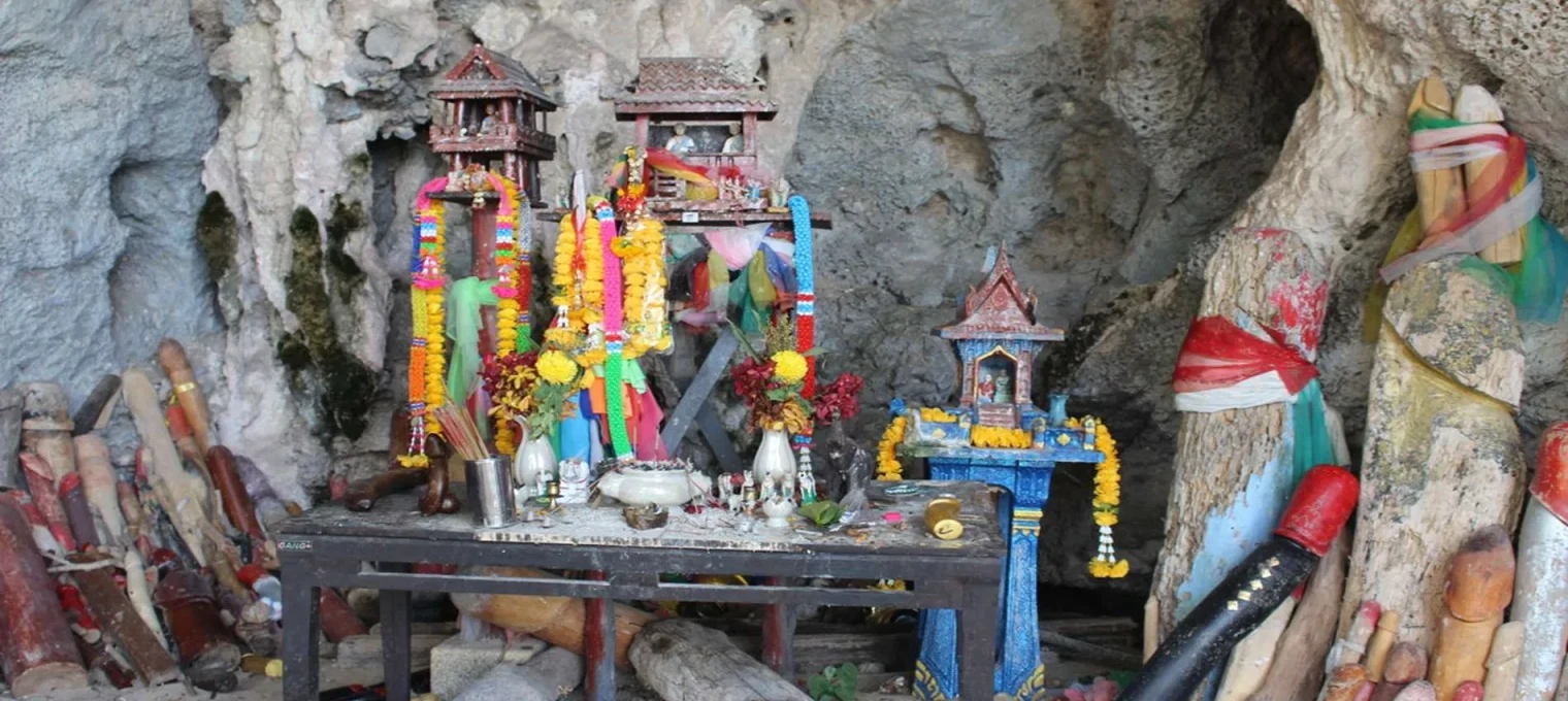 Colorful altars adorned with flowers inside a cave in Phuket, Thailand.
