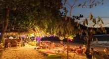 Beachside lounge area in Phuket, adorned with colorful lights at dusk.