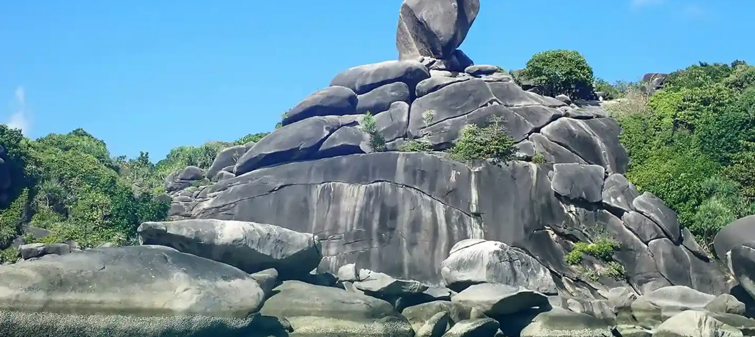 Large rock formation known as the "Boulder" on a tropical beach in Phuket, Thailand.