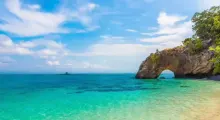 Stunning coastal view of turquoise waters and a natural rock arch in Phuket.