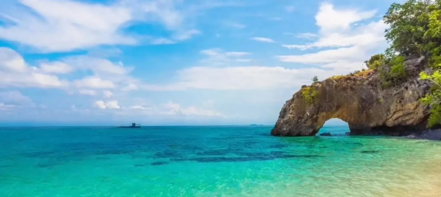 Stunning coastal view of turquoise waters and a natural rock arch in Phuket.