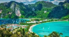 Stunning view of Phuket's coastline with lush mountains and clear turquoise waters.