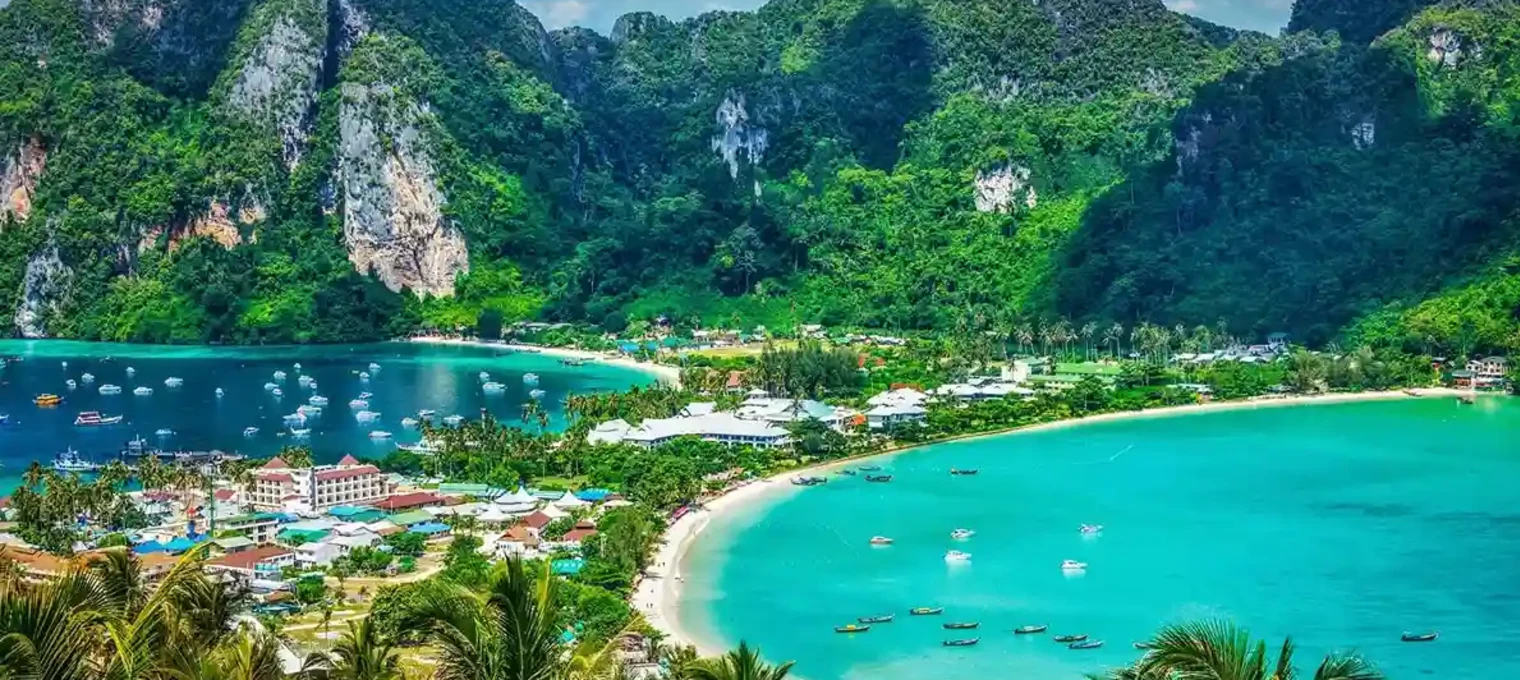 Stunning view of Phuket's coastline with lush mountains and clear turquoise waters.