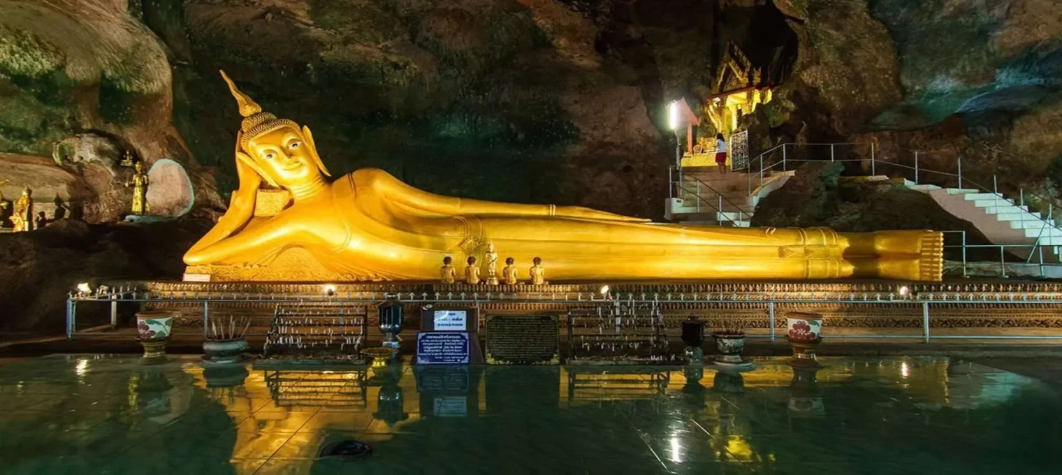 Reclining golden Buddha statue inside a cave temple in Phuket, Thailand.