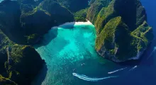 Aerial view of a stunning turquoise bay surrounded by lush green cliffs in Phuket.