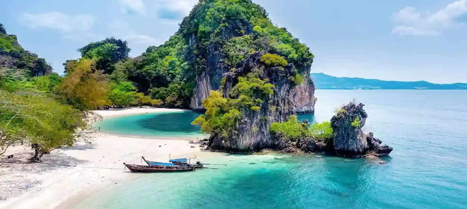 Stunning tropical beach in Phuket with turquoise waters and lush green cliffs.