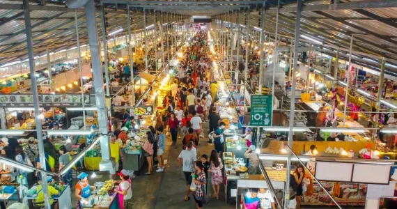 Торговая улица в Пхукете с людьми, уличной едой и яркими огнями.