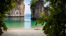 Scenic view of clear waters framed by rock formations and lush greenery in Phuket.