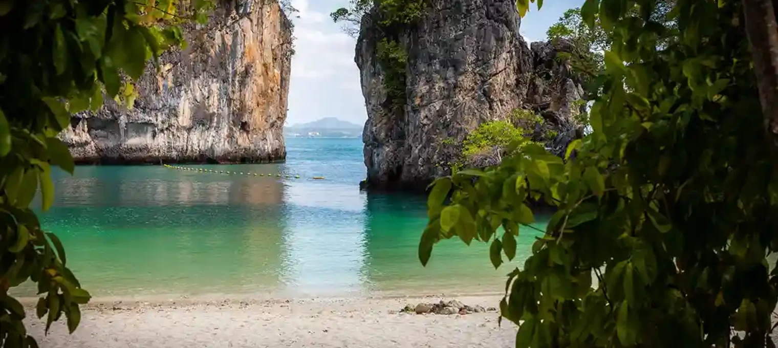 Scenic view of clear waters framed by rock formations and lush greenery in Phuket.
