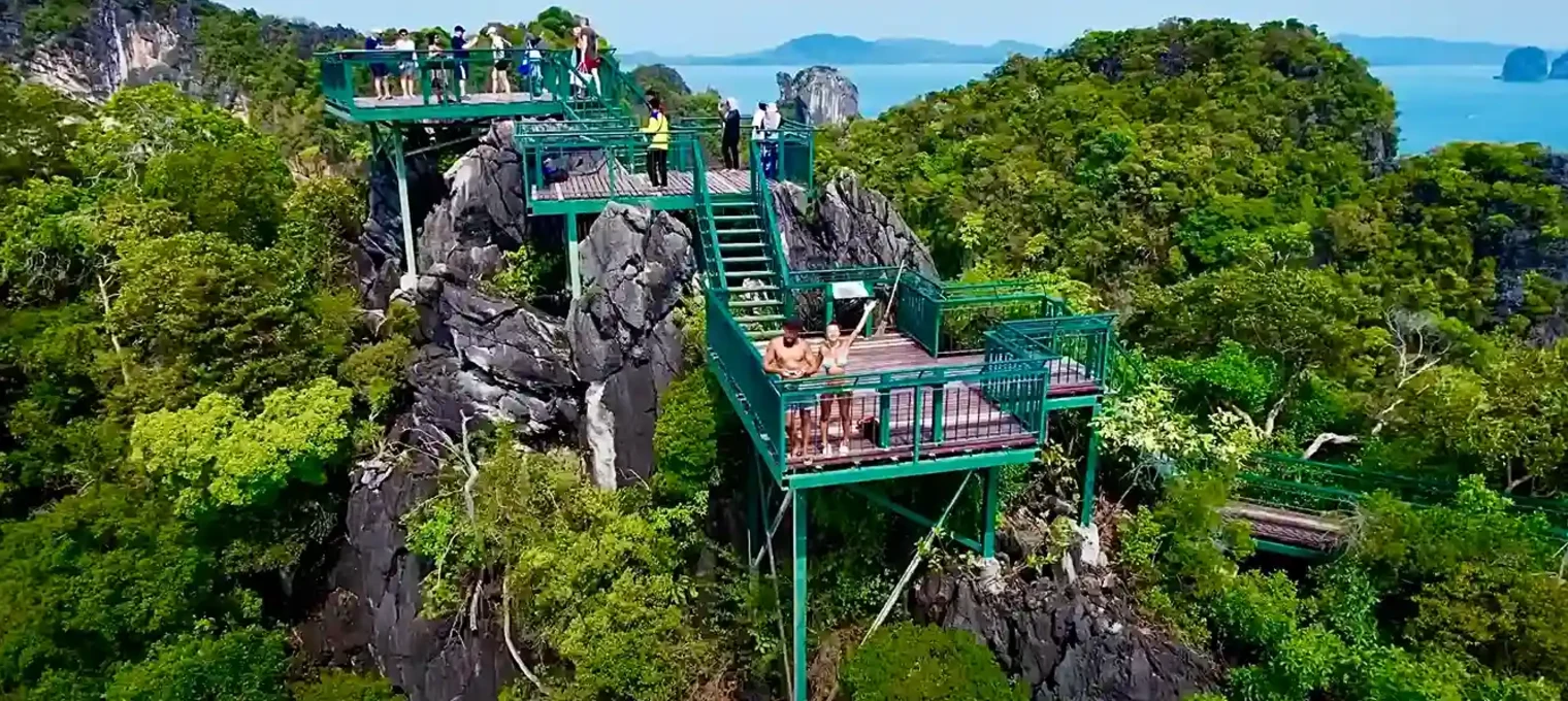 Suspended viewing platforms atop rocky cliffs in Phuket, surrounded by lush greenery and ocean views.