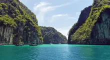 Stunning view of turquoise waters between lush green cliffs in Phuket, Thailand.