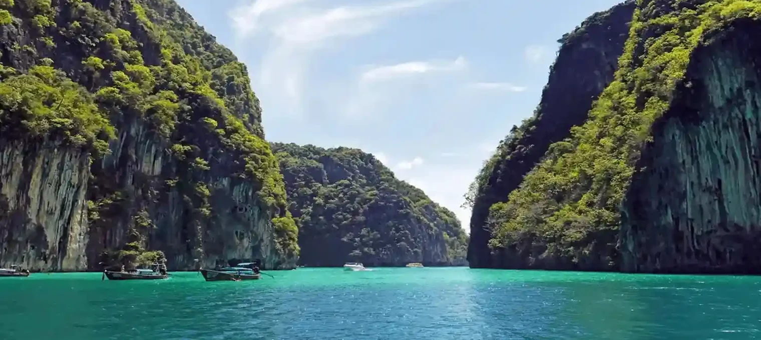 Stunning view of turquoise waters between lush green cliffs in Phuket, Thailand.