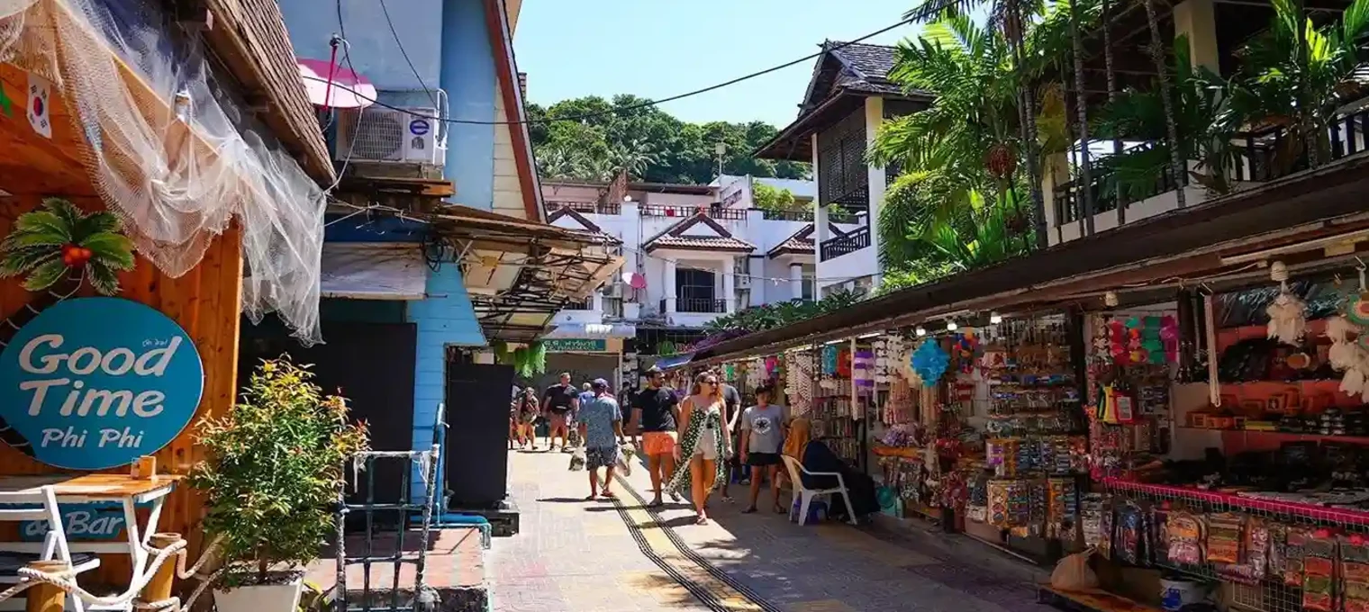 Colorful street market in Phuket, Thailand, with shops and tourists enjoying the day.