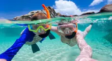 Two snorkelers explore clear turquoise waters in Phuket, enjoying underwater visibility.
