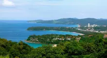 Scenic view of Phuket coastline with lush greenery and clear blue waters.