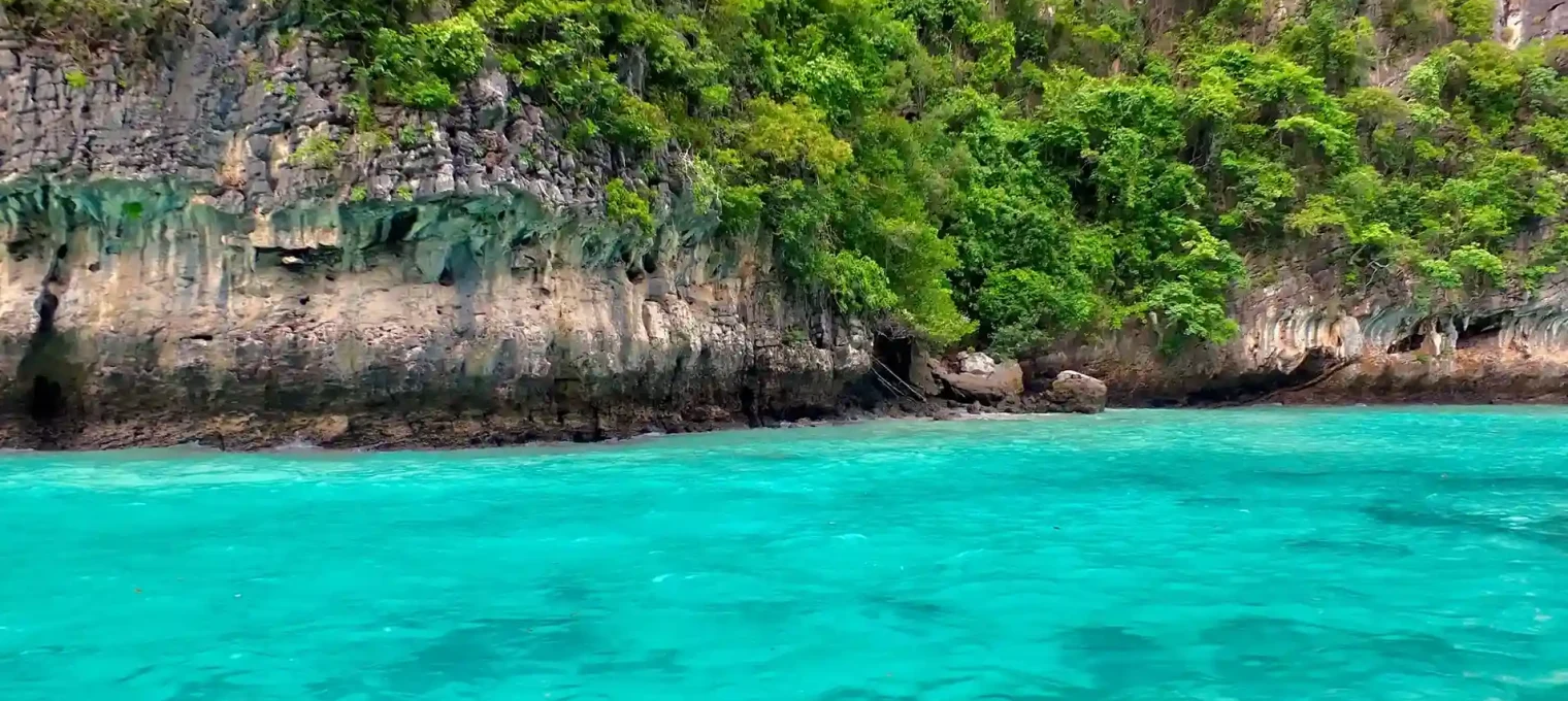 Scenic view of turquoise waters and lush greenery along Phuket's coastline.