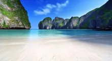 Turquoise waters and lush cliffs at a serene beach in Phuket, Thailand.