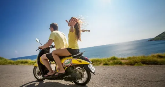 Два человека на скутере, наслаждаются поездкой у побережья Пхукета.