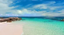 Stunning view of a turquoise beach in Phuket, with clear waters and a blue sky.